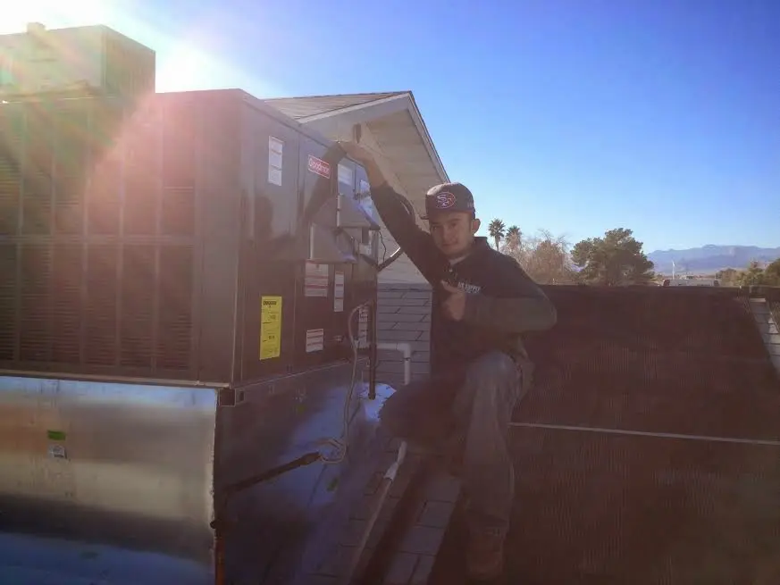 HVAC technician performing Air Duct Cleaning on a rooftop unit in Pace